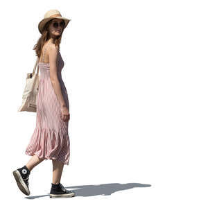 woman in a summer dress and wearing a hat walking