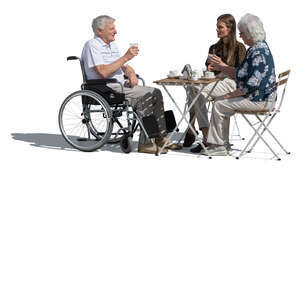 older man in a wheelvhair sitting in a cafe with family