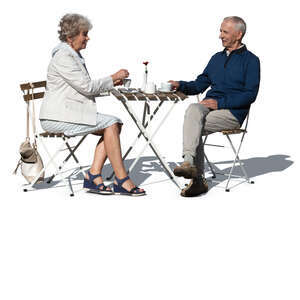 elderly couple sitting in an outdoor cafe