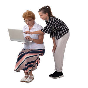 girl showing her grandmother how to use a computer