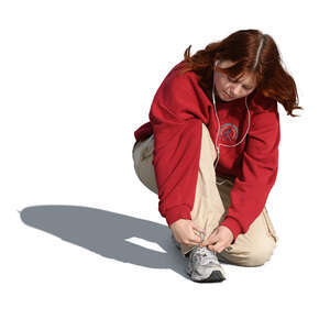 young woman squatting and tying her shoelaces