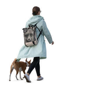 woman in an autumn jacket walking a dog