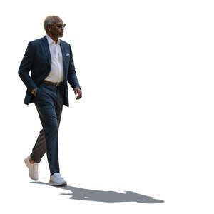 backlit black man in a grey suit walking