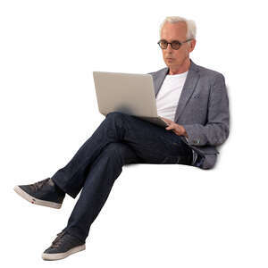 older gentleman sitting on a sofa with laptop
