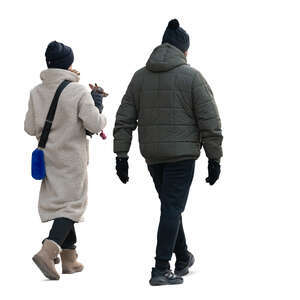 man and woman with a little dog walking in winter