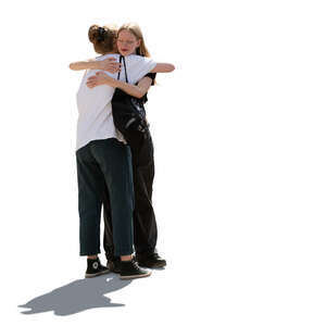 two backlit women hugging