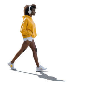 backlit black woman with headphones walking