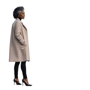 cut out grey haired black woman in a beige overcoat standing