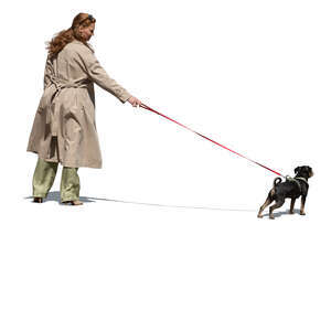 woman wearing a trenchcoat walking a dog