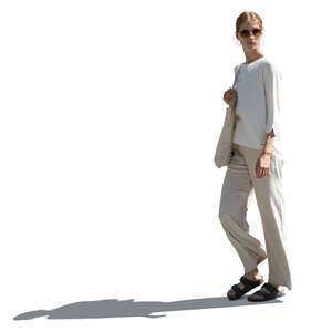 sidelit woman in relaxed white outfit walking