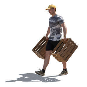 backlit man carrying wooden crates