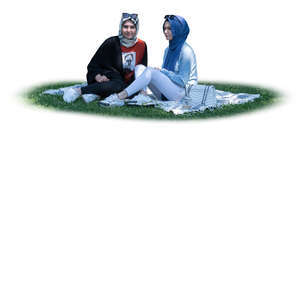 cut out two muslim girls sitting on the grass under a tree