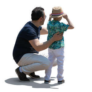 father squatting next to his son and talking