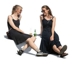 two women sitting outside and drinking