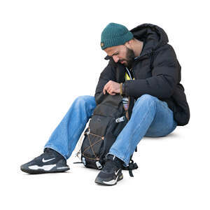 cut out man sitting and taking smth from his backpack