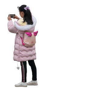 cut out asian girl in a pink coat standing and taking a picture