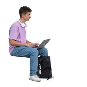 teenage boy sitting and working with computer