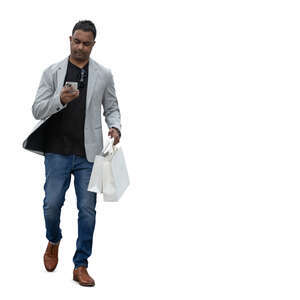 indian man with shopping bags and a phone walking