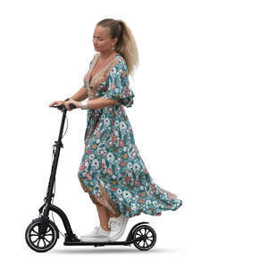 woman in a flowy summer dress riding a scooter