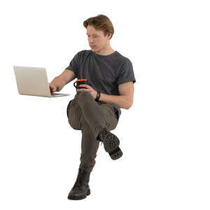 man sitting and drinking coffee and working with a computer