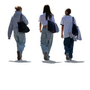 backlit group of three young women walking