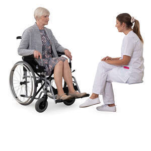 older woman in a wheelchair talking to a medical worker