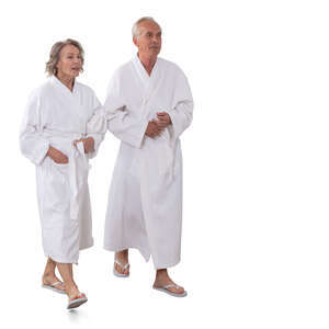 two older people wearing white bathrobes walking