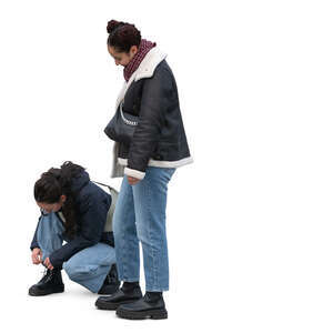 woman tying her shoe laces and her friend standing and waiting