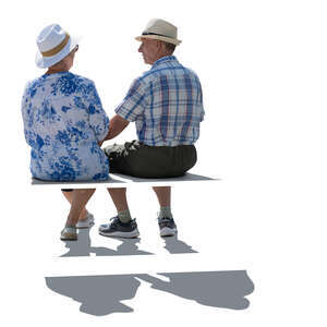 two backlit older people sitting on a bench