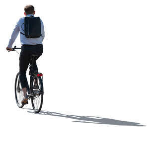 backlit office worker with a backpack riding a bike