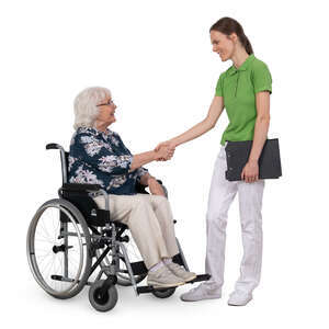 older woman in a wheelchair greeting a physical therapist