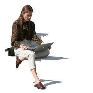 young woman sitting outside and working with laptop