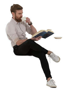 man drinking coffee and reading a book