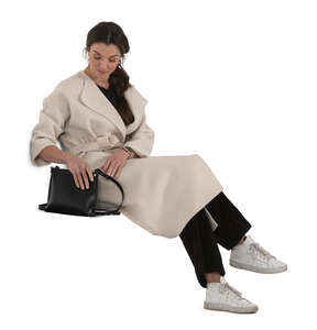 chic woman in a white overcoat sitting