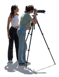 cut out backlit image of two women with a photo camera