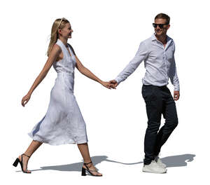 man and woman in white fancy summer outfits walking happily hand in hand