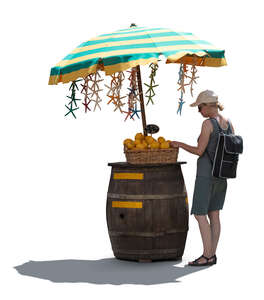 backlit woman buying lemons from and outdoor market stand