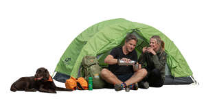 couple and a dog hiking and drinking tea in front of a tent