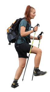 woman hiking up a hill using trekking poles