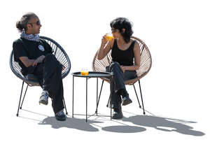 cut out backlit people sitting in an outdoor cafe and talking