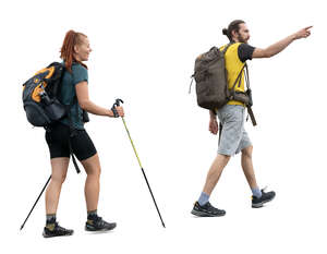 two people with backpacks and trekking poles hiking 