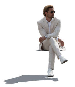 cut out backlit man in a white suit sitting