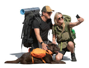 two hikers and a dog taking a selfie