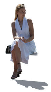 cut out elegant backlit woman in a white dress sitting