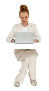 woman in a trendy white suit sitting behind the desk