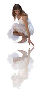 woman in a white dress squatting by the pool