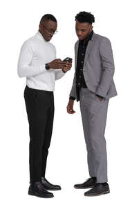 two black men standing and looking at a phone together