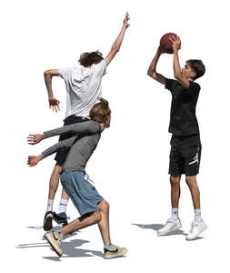 three teenage boys playing basketball outside 