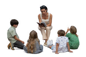 woman sitting and reading a book to a group of children