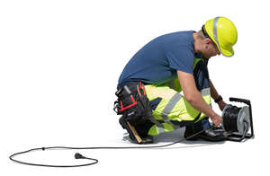 workman squatting and preparing an extension cord